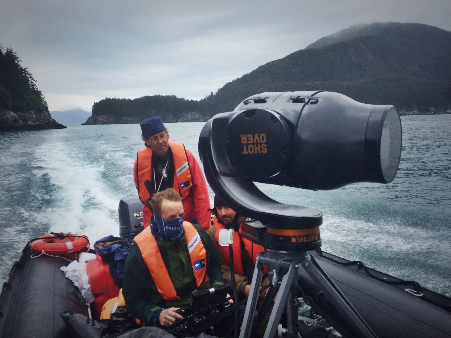 A documentary crew and mounted cinema camera aboard a small boat